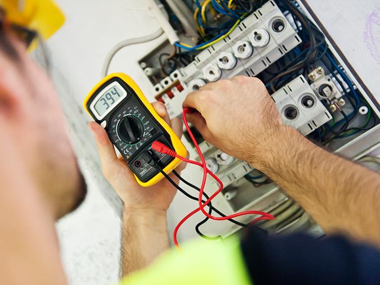 Elektryk sprawdzający natężenie prądu